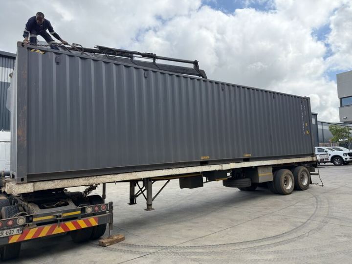 Shipping container arriving on a truck for conversion