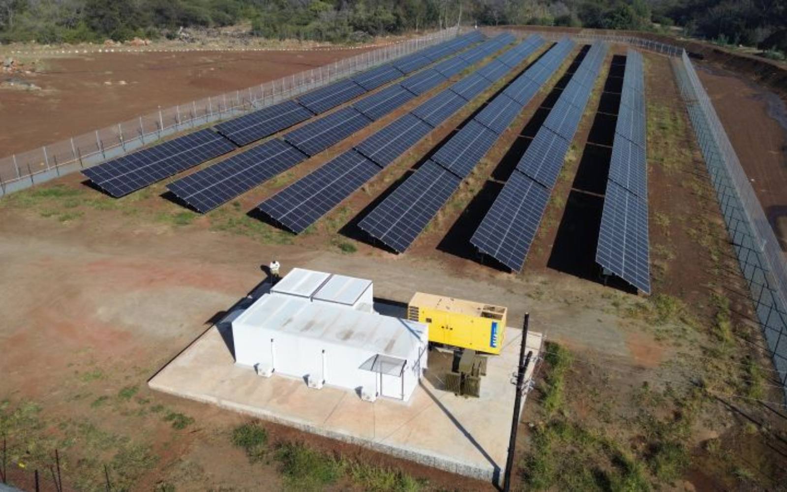 Aerial view of an off-grid solar plant with containerised battery and inverter rooms at a quarry